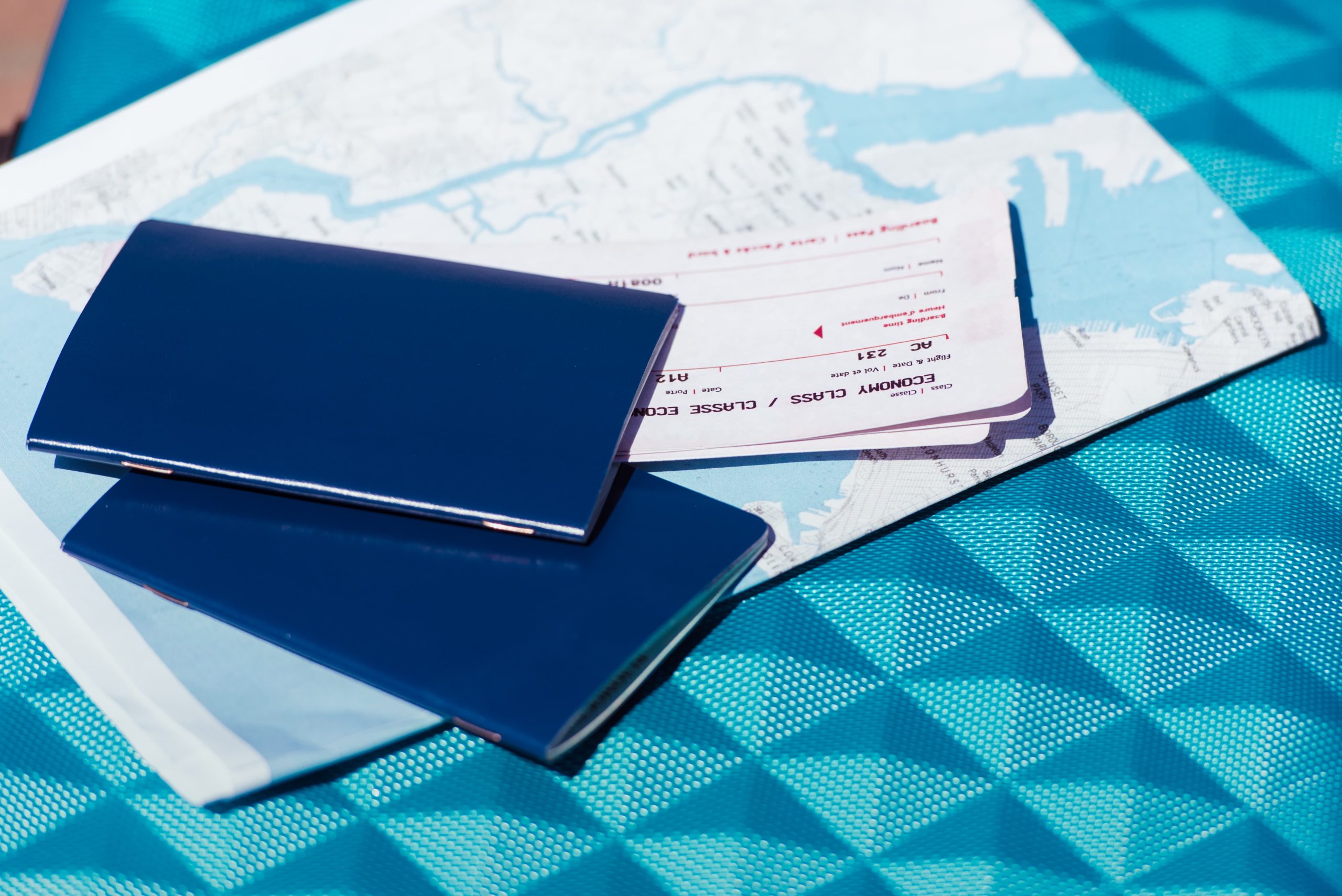 close up of map, two passports and tickets lying on blue baggage